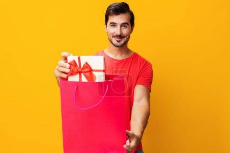 Photo for Discount man package gift happy buy shopper bag women background portrait sale shop fashion store lifestyle client purchase present yellow isolated surprise holiday day - Royalty Free Image