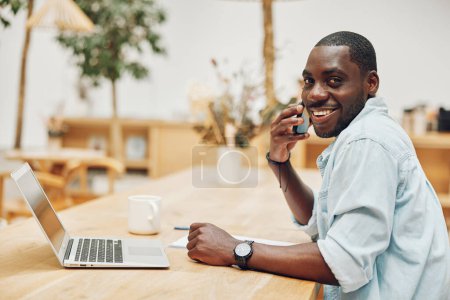 Photo for Office man smile lifestyle table person adult happy male technology laptop modern businessman computer business job young black african sitting professional working - Royalty Free Image