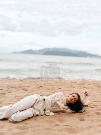 Téléchargez les photos : Summer Bliss : Une femme étonnante jouissant d'une sérénité tranquille à la plage - en image libre de droit
