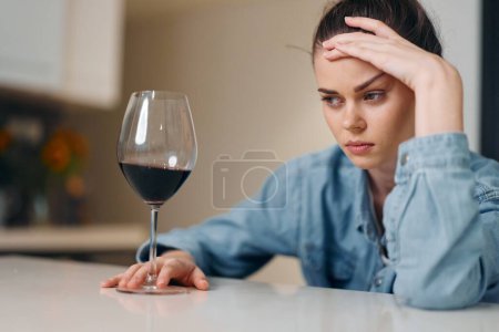 Foto de Mujer deprimida bebiendo vino sola: un retrato de tristeza y soledad. - Imagen libre de derechos