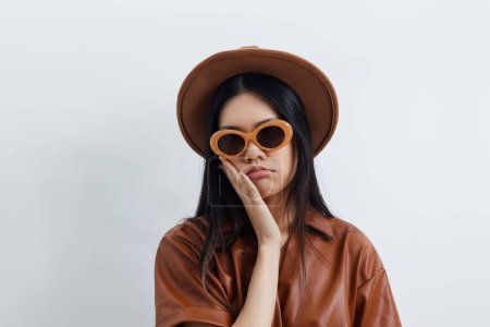 Téléchargez les photos : Asiatique femme attrayant visage beau style de vie lunettes de soleil glamour portrait cheveux mode vacances cosmétique chapeau Voyage beauté féminité modèle beige salon - en image libre de droit