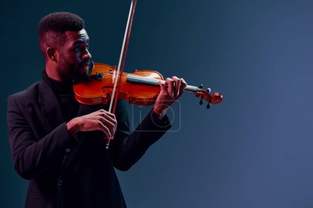 Photo for Elegant African American Violinist in Black Suit Performing on Dark Background with Passion and Skill - Royalty Free Image