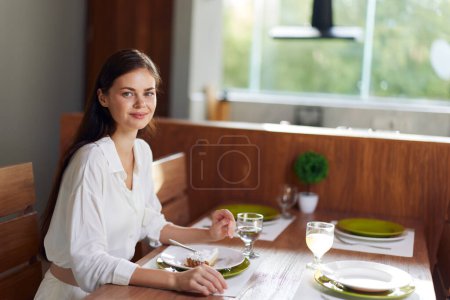Foto de Cena romántica Cita en casa Mujer sonriendo en éxtasis en la elegante mesa de comedor con deliciosa comida casera y vino Celebración alegre del amor y la felicidad - Imagen libre de derechos