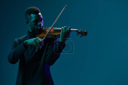 Violoniste classique en costume noir se produisant sur fond bleu avec style élégant et grâce, créant une musique harmonieuse