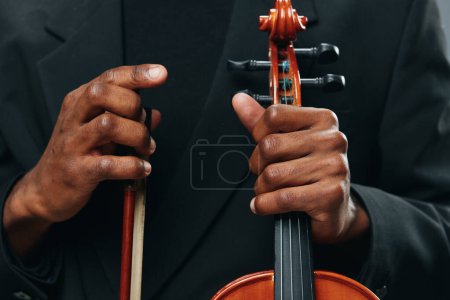Téléchargez les photos : Gros plan portrait de l'homme en costume jouant du violon avec arc à la main, concept de musique et d'art - en image libre de droit