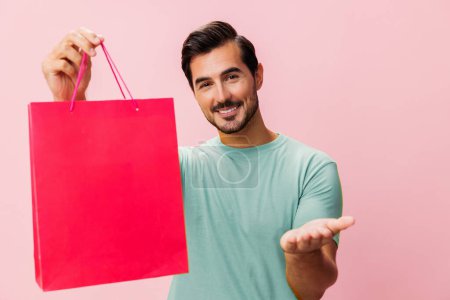 Téléchargez les photos : Homme sac rose client femmes acheter mode achat cadeau vacances boutique surprise isolé style de vie heureux shopper magasin paquet cadeau discount vente - en image libre de droit