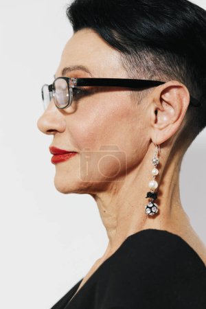 Téléchargez les photos : Femme à la mode en lunettes et boucles d'oreilles portant un haut noir et une robe rouge et blanche - en image libre de droit