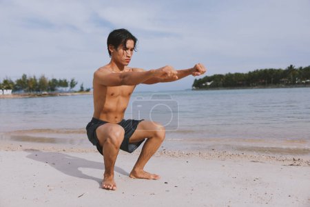 Foto de Atleta Asiático Activo Corriendo en la Playa: Un Hombre Musculoso disfrutando de Fitness y Libertad en un Entrenamiento de Verano - Imagen libre de derechos
