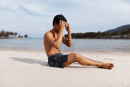 Téléchargez les photos : Homme asiatique actif courant sur la plage, fuyant la force et la liberté au milieu de l'océan serein Coucher de soleil - en image libre de droit