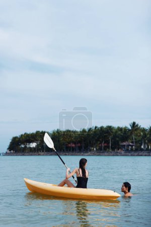 Sérénité au coucher du soleil : une aventure de kayak insouciante sur un lac tropical