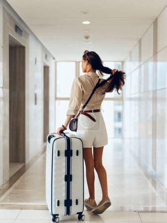 Photo for Modern Businesswoman with Suitcase Walking towards Departure Gate at Airport Terminal, Ready for an International Trip - Royalty Free Image