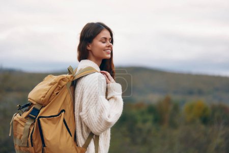 Téléchargez les photos : Femme souriante à la montagne Aventure : Liberté et bonheur en plein air au printemps - en image libre de droit