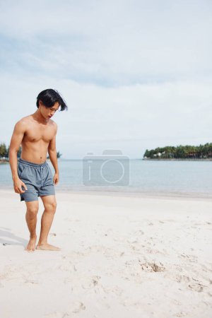 Photo for Muscular Asian Athlete Enjoying Beach Run: Capturing the Power and Freedom of an Active Lifestyle - Royalty Free Image