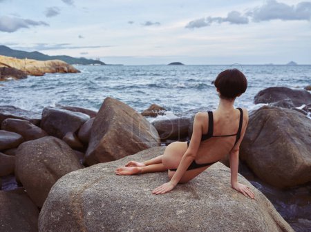 Photo for Sexy Summer Swimsuit: Beautiful Woman with a Slim Figure on a Tropical Beach, Posing with Confidence and Happiness against Stunning Rock Formation. - Royalty Free Image