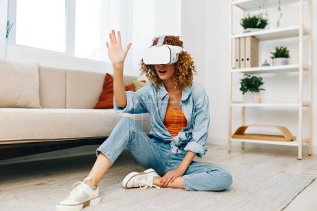 Foto de Realidad virtual: Una experiencia alegre para mujeres en una sala de estar moderna con gafas de realidad virtual futuristas - Imagen libre de derechos