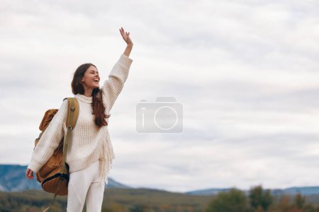 Foto de Aventura en la montaña: Mujer sonriente disfrutando del senderismo al aire libre en primavera - Imagen libre de derechos