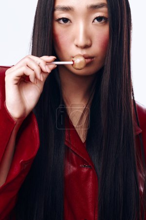 Foto de Mujer joven con el pelo largo negro cepillarse los dientes delante del espejo con cepillo de dientes en la boca - Imagen libre de derechos