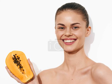 Téléchargez les photos : Papaye fraîche tenue par une femme avec une tranche devant sur fond blanc, concept de fruits tropicaux - en image libre de droit