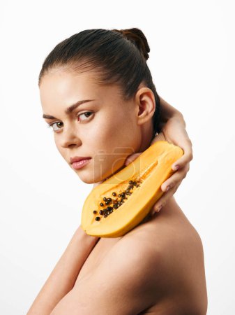 Téléchargez les photos : Attrayant femelle tenant papaye mûre sur son épaule, belle et saine, isolé sur fond blanc - en image libre de droit