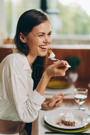 Foto de Mujer feliz disfrutando de una cena romántica en casa con delicioso pastel casero y vino - Imagen libre de derechos