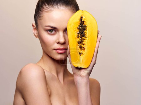Belle jeune femme avec masque facial aux fruits de papaye, concept de soins de la peau, isolé sur fond blanc