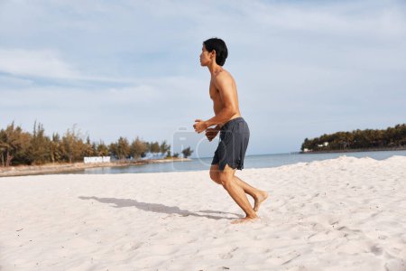 Téléchargez les photos : Homme Asiatique Musclé Profitant de vacances à la plage tropicale Abs of Paradise - en image libre de droit