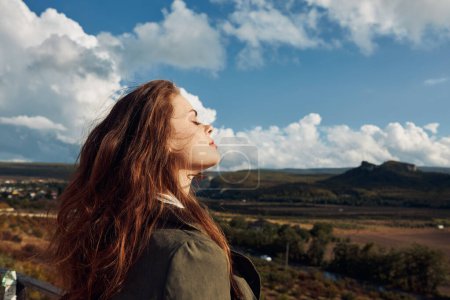 Téléchargez les photos : Femme debout sur une colline regardant le ciel, contemplant la beauté de la nature et réfléchissant sur la vie - en image libre de droit