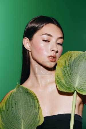Téléchargez les photos : Beauté au visage frais : une jeune femme pure joie au milieu de la verdure tropicale - en image libre de droit