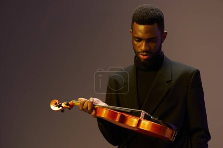Photo for Elegant man in suit holding a violin against a dark background for music and arts concept - Royalty Free Image