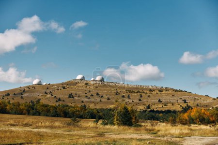 Trois puissants télescopes capturant la beauté du cosmos depuis un observatoire situé au sommet d'une colline par temps clair