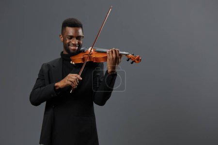 Photo for Elegant African American Violinist in Black Suit Performing on Gray Background with Passion and Grace - Royalty Free Image