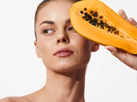Téléchargez les photos : Woman Holding Papaya in Front of Face with Eyes Closed in Peaceful Moment of Serenity and Relaxation - en image libre de droit