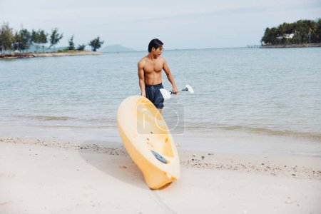 Happy Asian Man kayak sur la plage tropicale : vacances d'été Fun