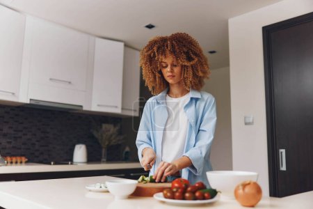 Jeune femme afro-américaine cuisine délicieux repas fait maison dans sa cuisine à la maison