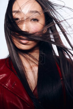 Stylish Woman with Long Black Hair in Red Leather Jacket Standing in the Wind
