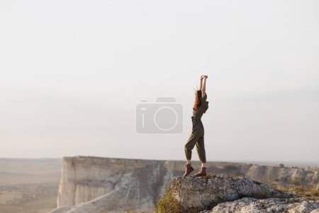 Téléchargez les photos : Femme debout sur le sommet de la montagne avec les bras levés dans Voyage aventure beauté portrait - en image libre de droit