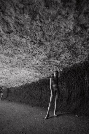 Exploring the mysterious cave man and woman standing together in the dark underground beauty of nature