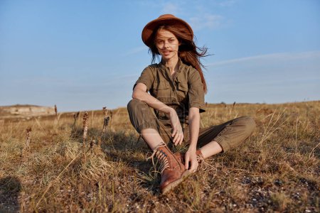 Téléchargez les photos : Femme se détendre sur un terrain herbeux avec les pieds dans l'air, profiter de la nature et des loisirs - en image libre de droit