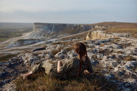 Frau genießt spektakuläre Aussicht auf das Tal, während sie auf einer Klippe sitzt, Reise Abenteuer Schönheit Landschaft Entdeckungskonzept