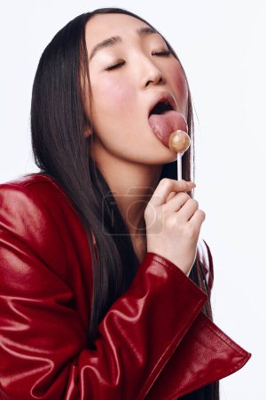 Joyful woman with lollipop in mouth posing for camera with big smile