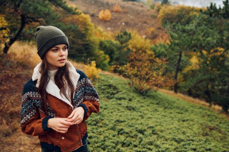 A stylish young woman exploring the beauty of autumn in a tranquil forest setting