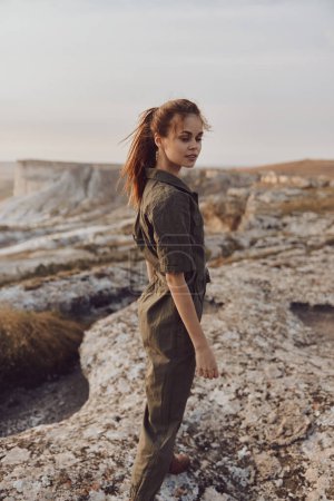 Explorer la beauté de la nature une femme en combinaison verte debout sur un rocher dans le désert