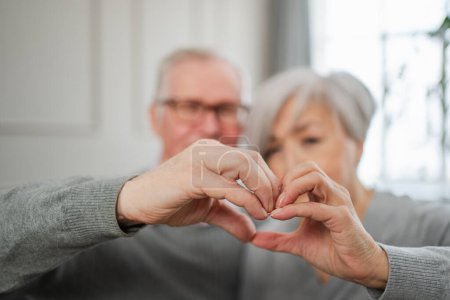 Love heart shape peace. Senior older couple making heart shape with their hands. Adult mature old husband wife showing heart sign. Happy pensioner family. I love you happy valentines day