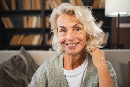 Porträt einer selbstbewussten europäischen Seniorin mittleren Alters. Ältere ältere Dame um die 60 lächelt zu Hause. Glücklich attraktive Senior weiblich aussehende Kamera Nahaufnahme Gesicht Kopfschuss Porträt. Glückliche Menschen