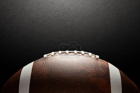 Téléchargez les photos : American football ball on dark textured background with space for text. - en image libre de droit