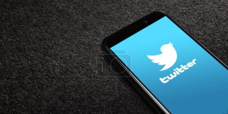Foto de Twitter logo on smartphone screen on black textured background. Twitter is a microblogging and social networking service. Elon Musk closes Twitter acquisition deal. Moscow, Russia - October 27, 2022. - Imagen libre de derechos