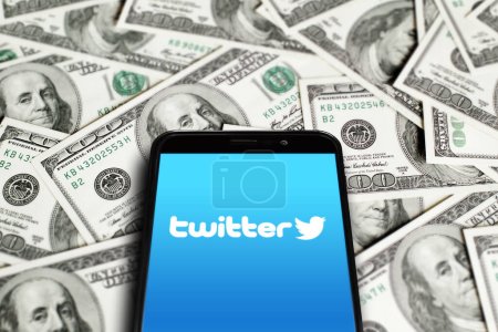 Photo for Twitter logo on smartphone screen on background of dollars. Twitter is a microblogging and social networking service. Elon Musk closes Twitter acquisition deal. Moscow, Russia - October 27, 2022. - Royalty Free Image
