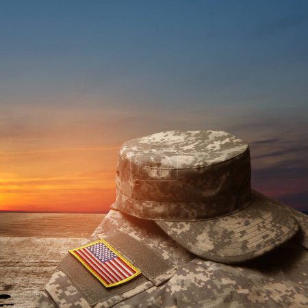 USA military uniform with insignias on old wooden table on sunset sky background. Memorial Day or Veterans day concept.