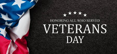 Foto de Closeup of American flag with Text Veterans Day Honoring All Who Served on black textured background. American holiday banner. - Imagen libre de derechos