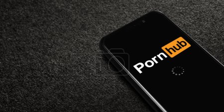 Téléchargez les photos : Smartphone avec logo Pornhub sur fond texturé noir. Pornhub est un site pornographique de partage de vidéos et de pornographie. Moscou, Russie - 21 février 2022. - en image libre de droit